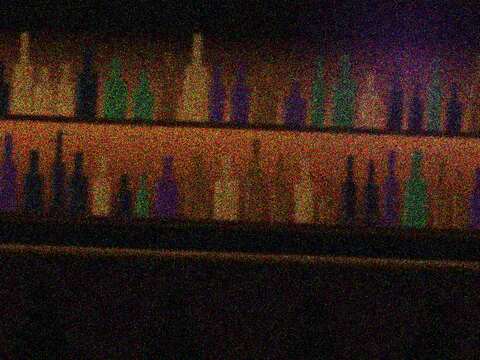 The back bar: shelves of bottles lit from behind.